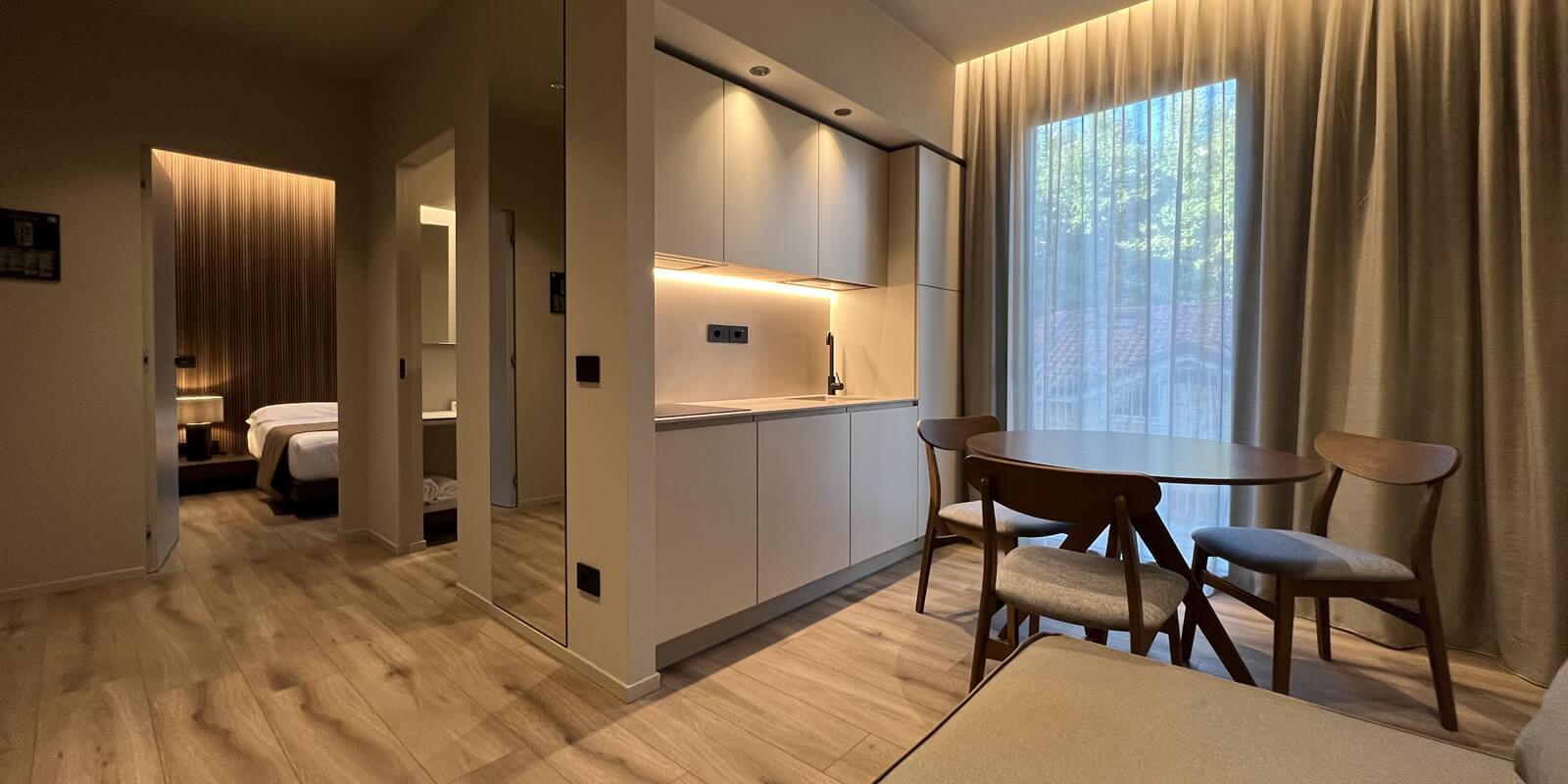 Modern apartment with kitchen, dining area, and separate bedroom.